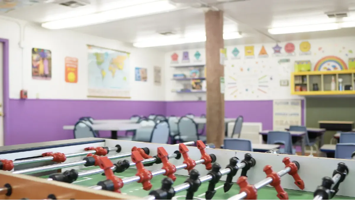The school-age room with a foosball table and a world map